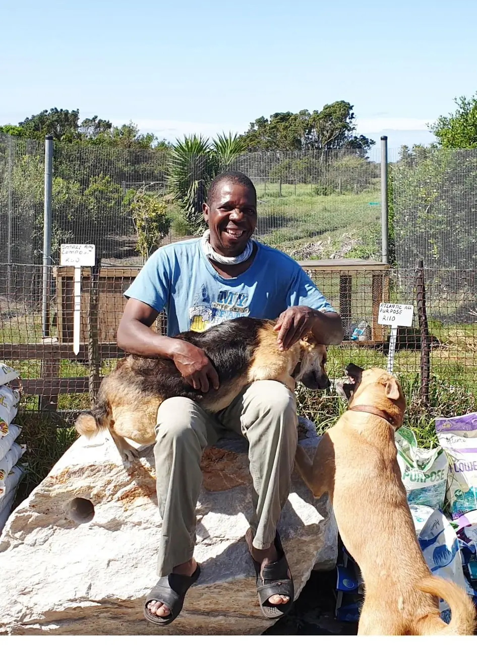 Tichafa Maredza with the nursery dogs Teddy and Freddy